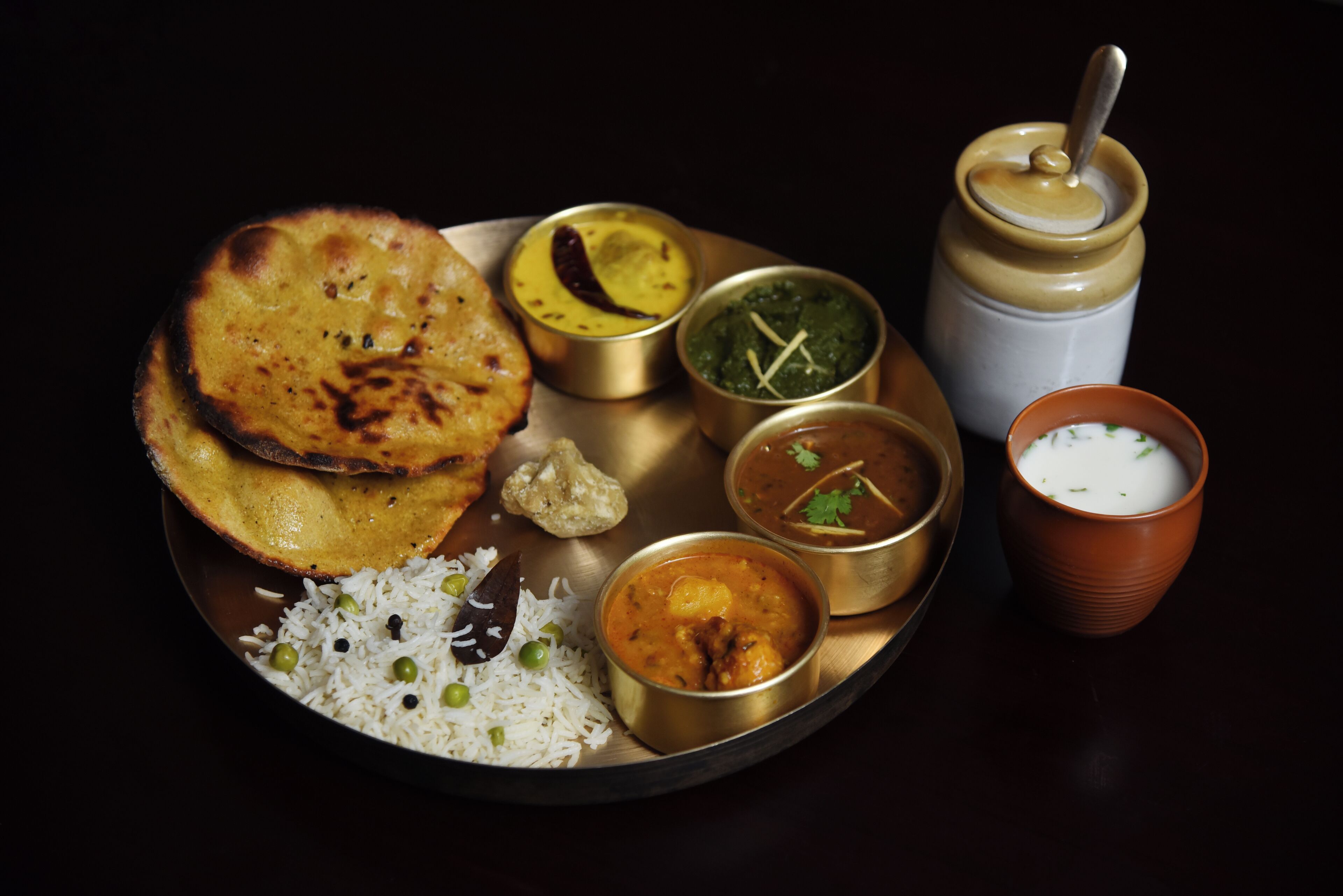 A plate of Indian cuisine including naan, rice, and various curries.