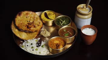 A plate of Indian cuisine including naan, rice, and various curries.