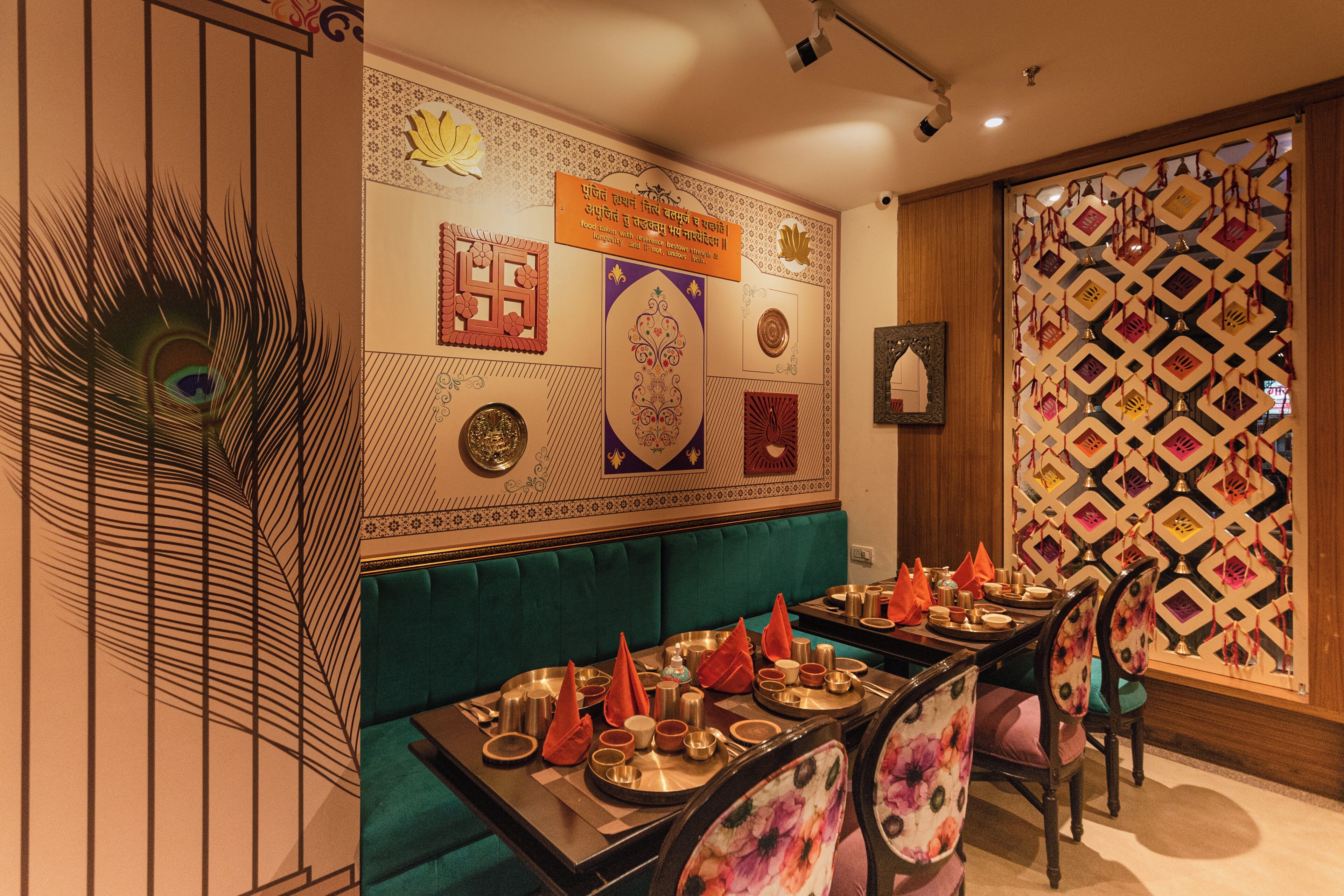 A restaurant with a green booth seating area, traditional decor, and a patterned wall.