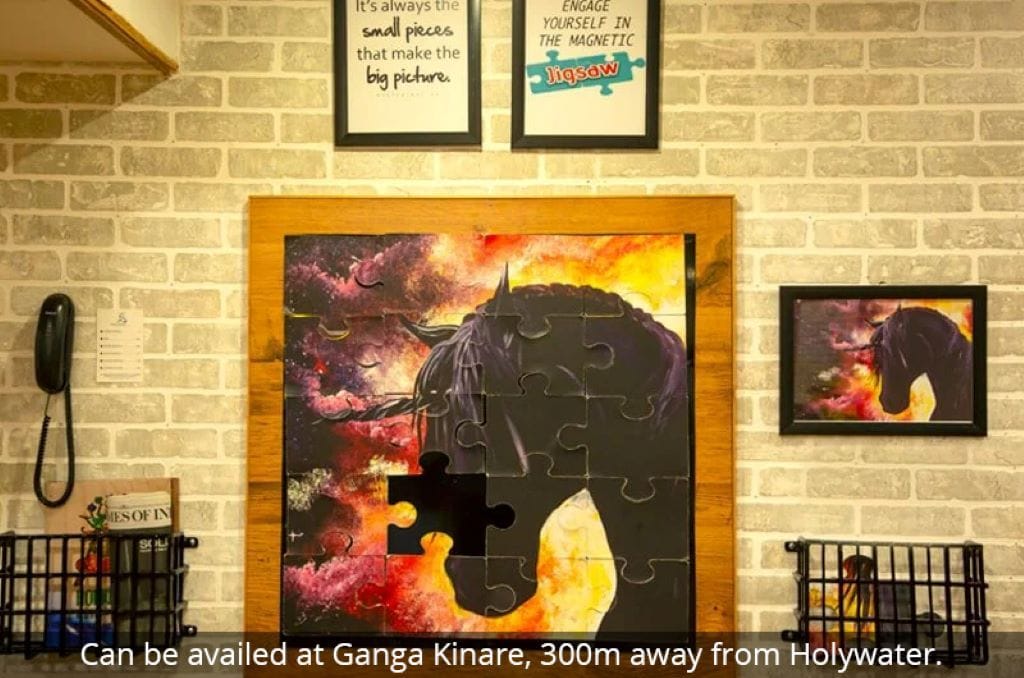 A wall with a large jigsaw puzzle artwork of a buffalo, framed and hung on a brick wall.