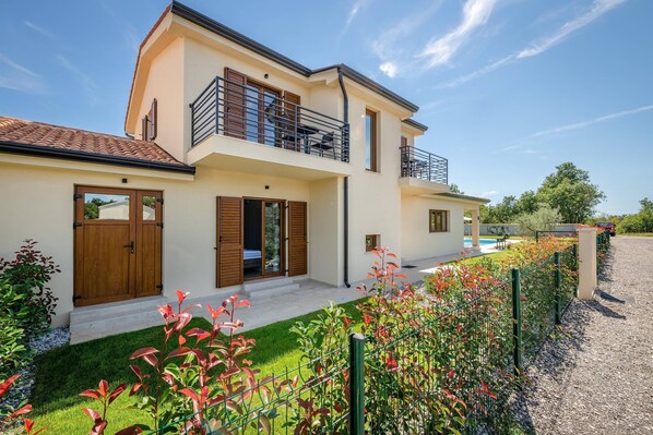 A two-story house with a balcony, a swimming pool, and a well-maintained garden. - Holiday house Luca in Poreč (Porec)