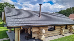 A log cabin with a sloped roof, a chimney, and a window.