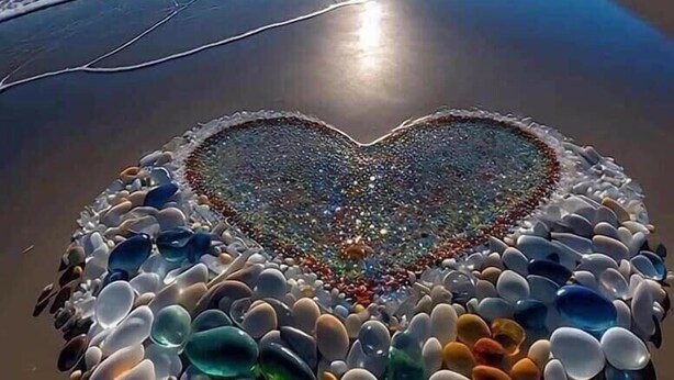 A beach with a heart-shaped arrangement of colorful pebbles in the center. - Coralina Hotel (Tuy Hoa)
