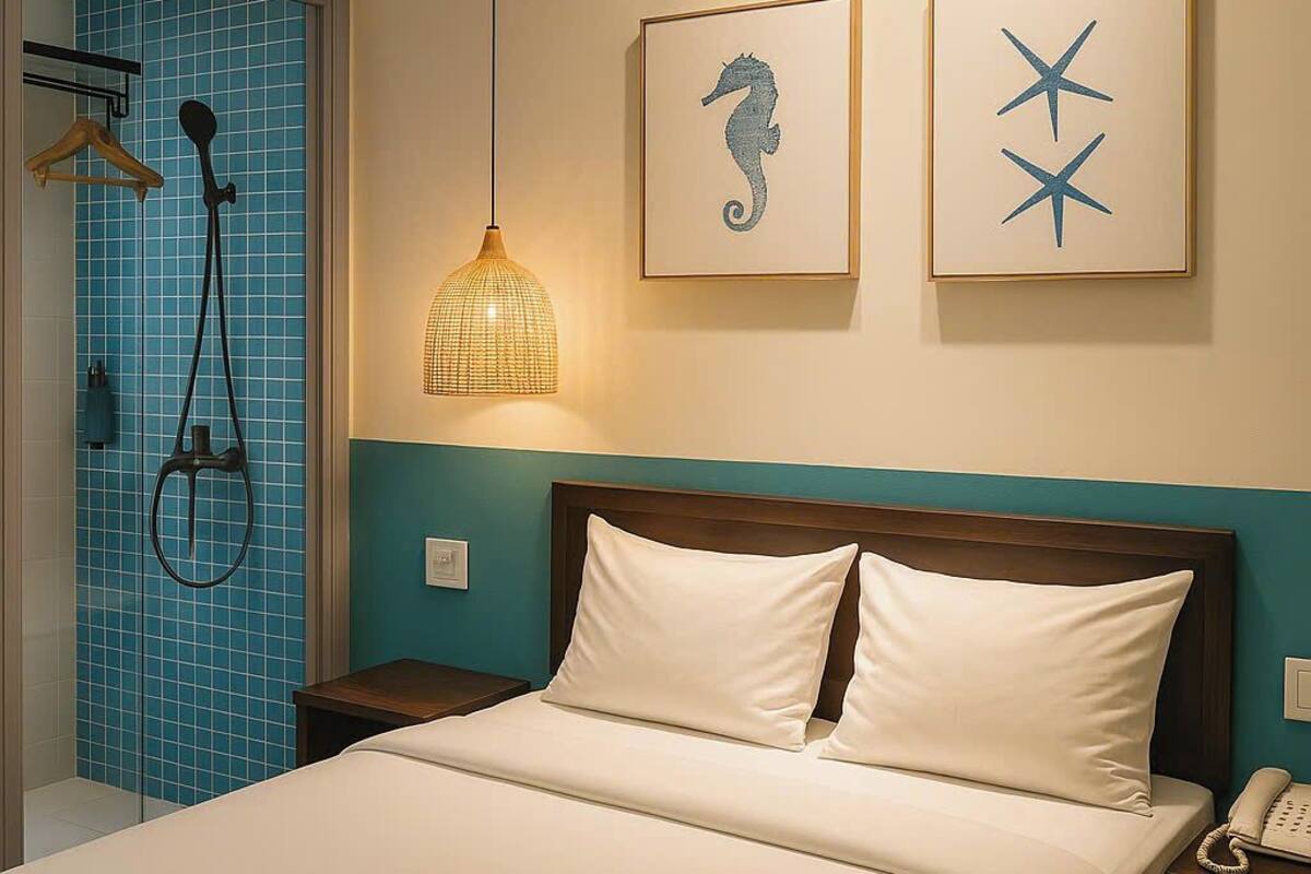 Une chambre d’hôtel comprenant un lit, une table de chevet, un téléphone, une douche et deux œuvres d’art accrochées au mur.