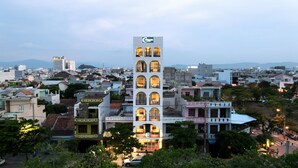A multi-story hotel with a central tower featuring balconies and a prominent sign. - Coralina Hotel (Tuy Hoa)