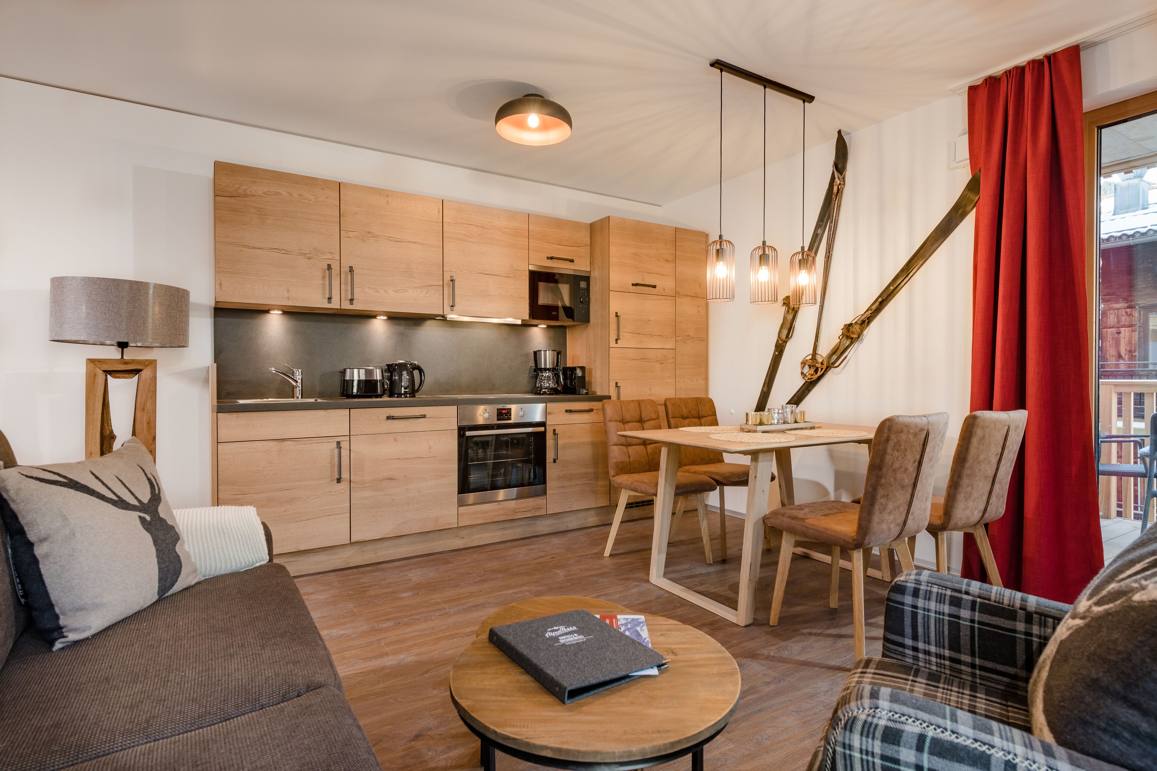 Una cocina moderna con armarios de madera, un comedor con mesa y sillas, y una zona de estar acogedora con un sofá y una mesa de centro.