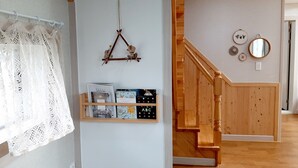 Eine Treppe mit Holzwertlauf und einer an der Wand befestigten Ablage mit Büchern und Dekoration.