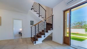 A modern staircase with a glass door leading outside.