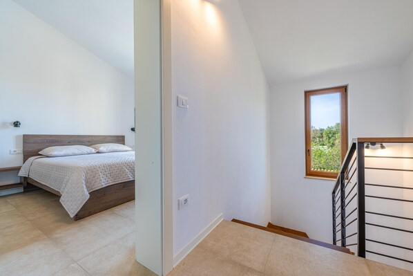 Una camera da letto con un letto, una finestra e una scala.