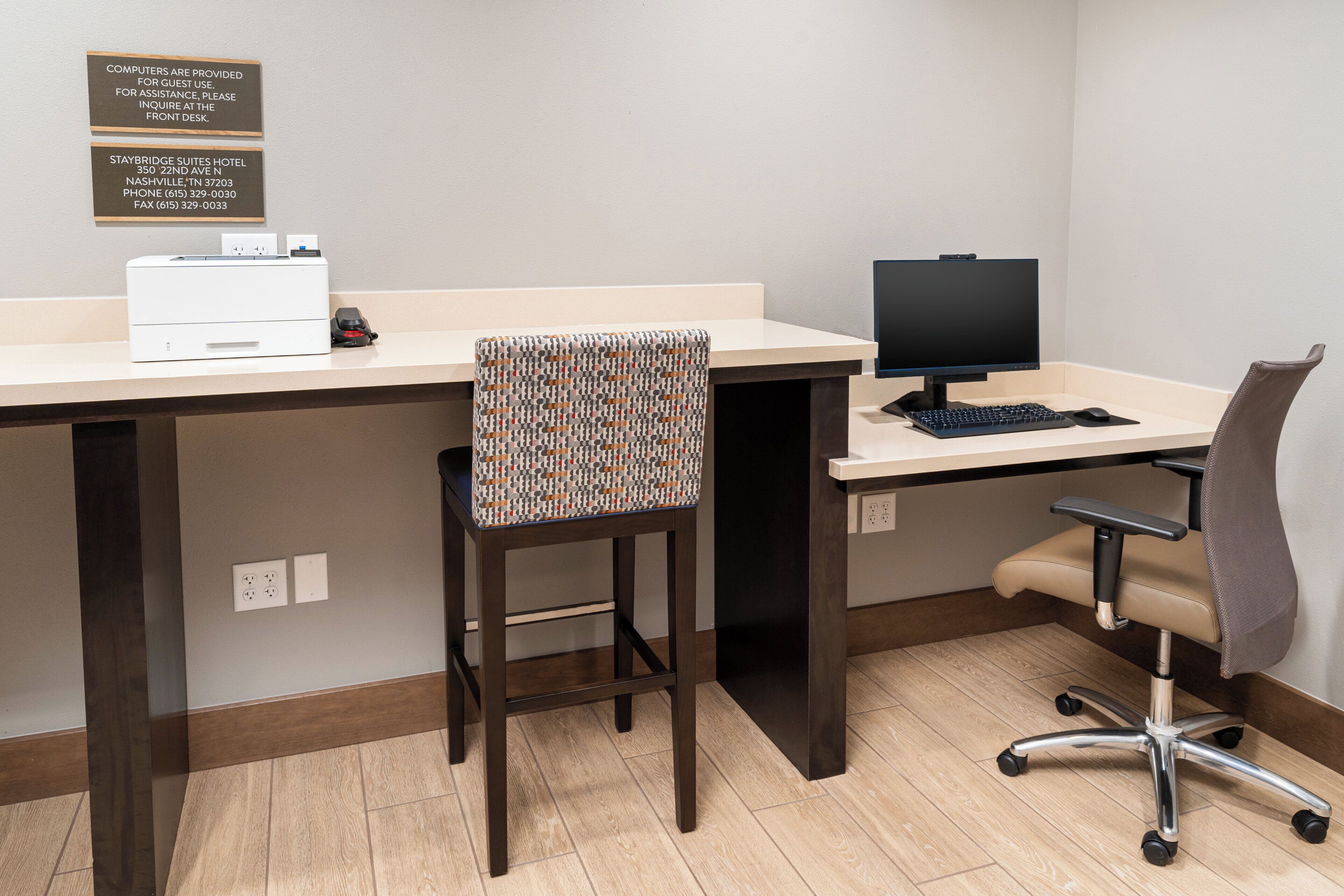 A hotel workspace with a desk, computer, and office chair.