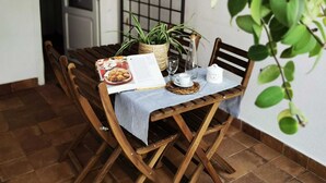 Un tavolo da pranzo con sedie, un menu, un bicchiere, una bottiglia e una pianta in vaso.