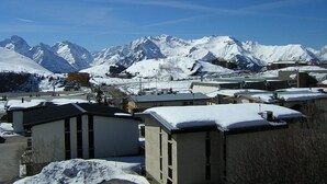 A snow-covered mountain town with modern buildings and a clear view of snow-capped peaks in the background. - Cozy Studio for 4 with South-Facing Balcony, Near Slopes and Shops - Pet Friendly (Huez)
