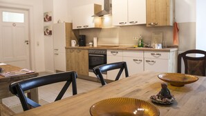 Een moderne keuken met houten kastjes, een eettafel met stoelen en een decoratieve schaal op tafel.
