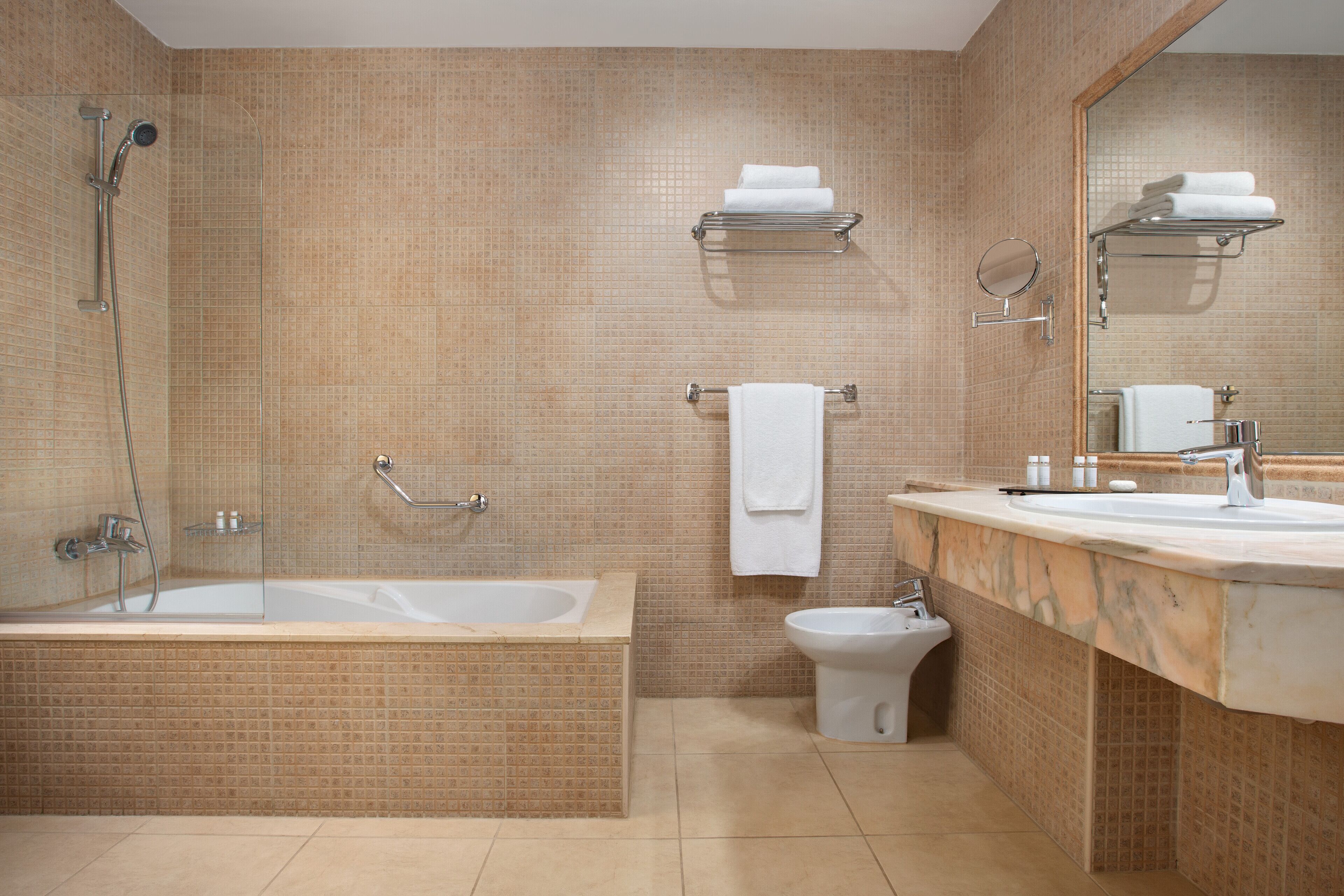 A bathroom with a bathtub, a shower, a toilet, a sink, and a mirror.