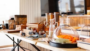 Un buffet proposant une variété de plats, notamment des pots de tartinades et un plat couvert de légumes.