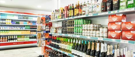 A liquor store with shelves stocked with various bottles and cans of alcohol.