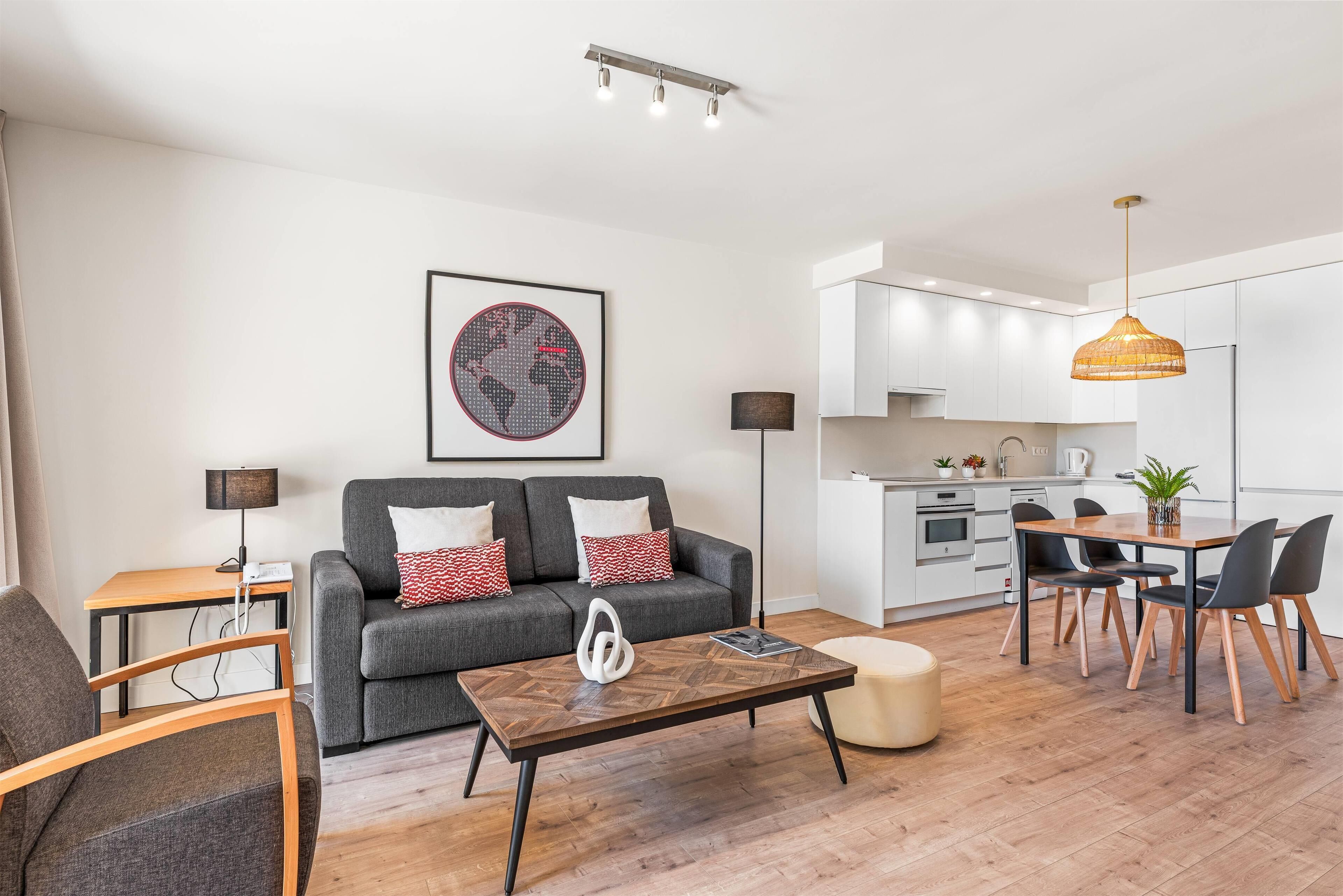 A modern living room with a sofa, coffee table, and dining area.