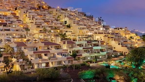 Un quartier résidentiel densément peuplé, situé sur une colline, avec de nombreux immeubles, chacun doté de balcons et de terrasses.