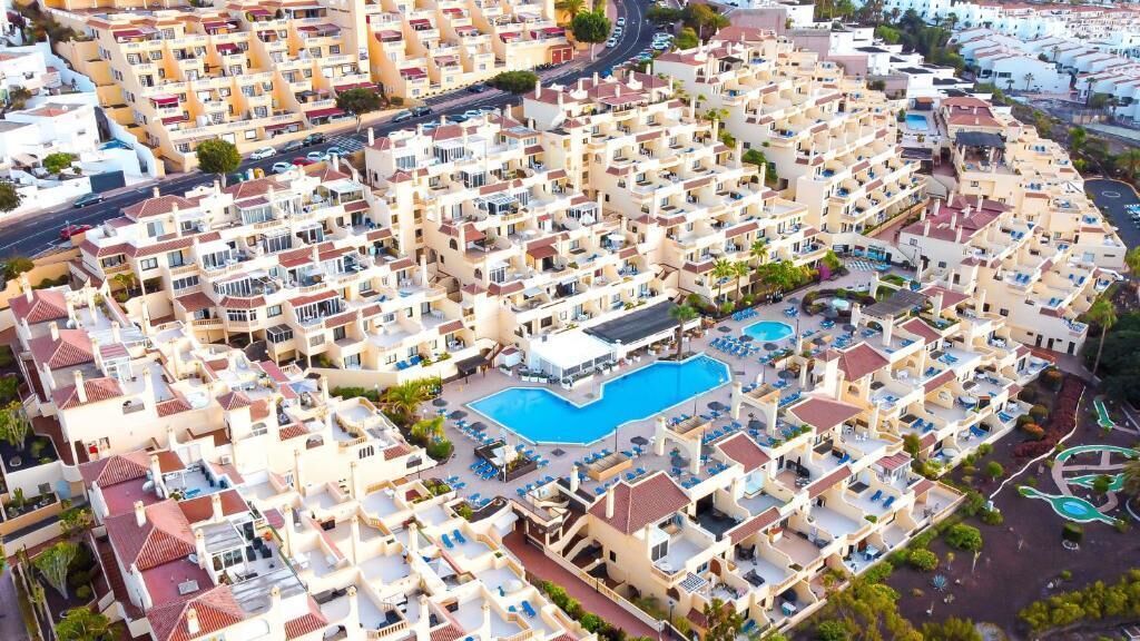 A residential area with multiple apartment buildings, a central swimming pool, and a circular driveway.