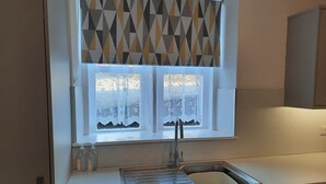 A kitchen with a window, a sink, and a cabinet. - Well appointed cottage on a working hill farm (Otley)