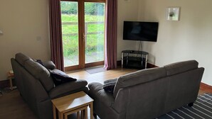 A living room with a sofa, a coffee table, and a television.