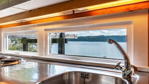 A kitchen with a stainless steel sink and a window overlooking a lake. - Holiday Home "Adlerhorst Über Dem Bodensee" with Panoramic Glazing, Terrace and Lake View (Sipplingen)