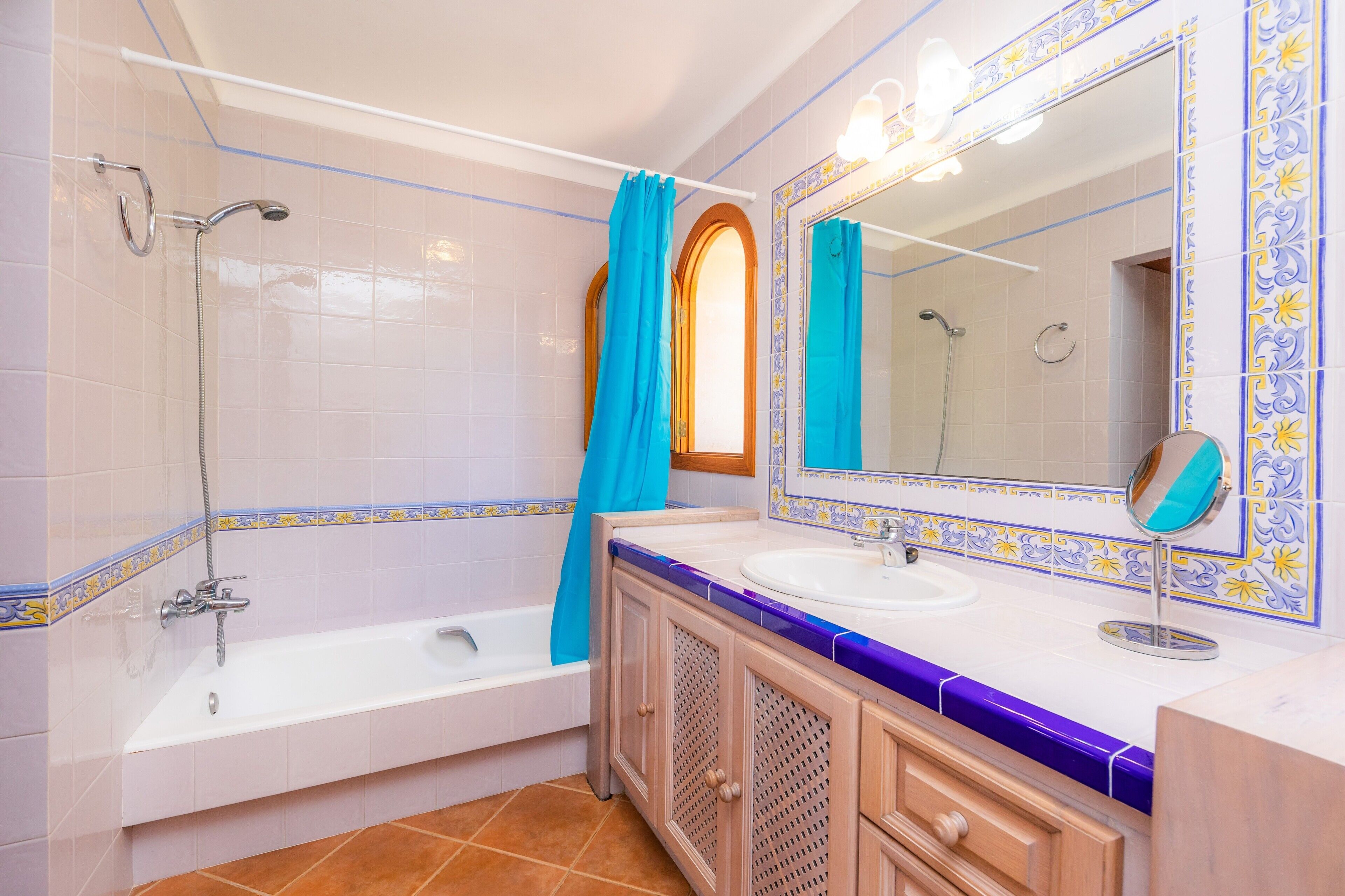 Un baño con bañera, ducha, tocador con espejo y lavabo.