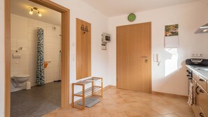 Una cocina moderna con horno integrado, una puerta de madera y un calendario en la pared.