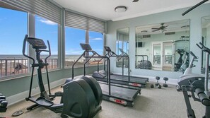 A home gym with treadmills, an elliptical, and dumbbells.