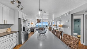 A modern kitchen with a central island, white cabinetry, and stainless steel appliances.