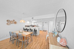 A modern kitchen with white cabinets, a central island, and bar stools.
