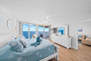 A bedroom with a bed, a dresser, a ceiling fan, and a view of the ocean. - Oceanfront Spectacular Views on Traffic Free Beach Unit 803 at Shores Club (Daytona Beach Shores)