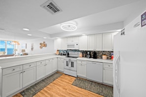 A modern kitchen with white cabinets, a microwave, stove, and dishwasher. - #803 Shores Club Oceanfront Traffic Free Beach 2/2 (Daytona Beach Shores)