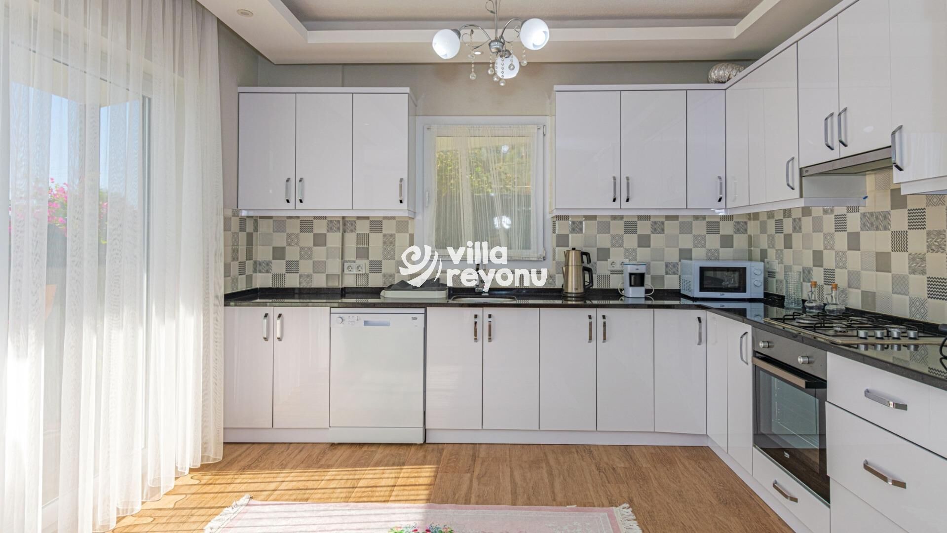 A modern kitchen with white cabinets, a microwave, a coffee maker, and a stove.