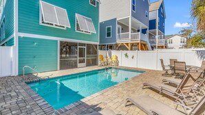 A swimming pool with a brick border, lounge chairs, and a covered patio area. - Beautiful beach home! Private pool! Dates in August have been discounted! (Surfside Beach)