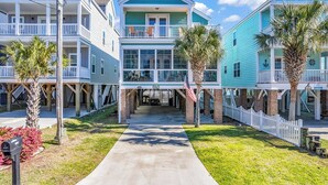 A row of coastal-style houses with balconies, a central walkway, and a US Mail mailbox. - Beautiful beach home! Private pool! Dates in August have been discounted! (Surfside Beach)