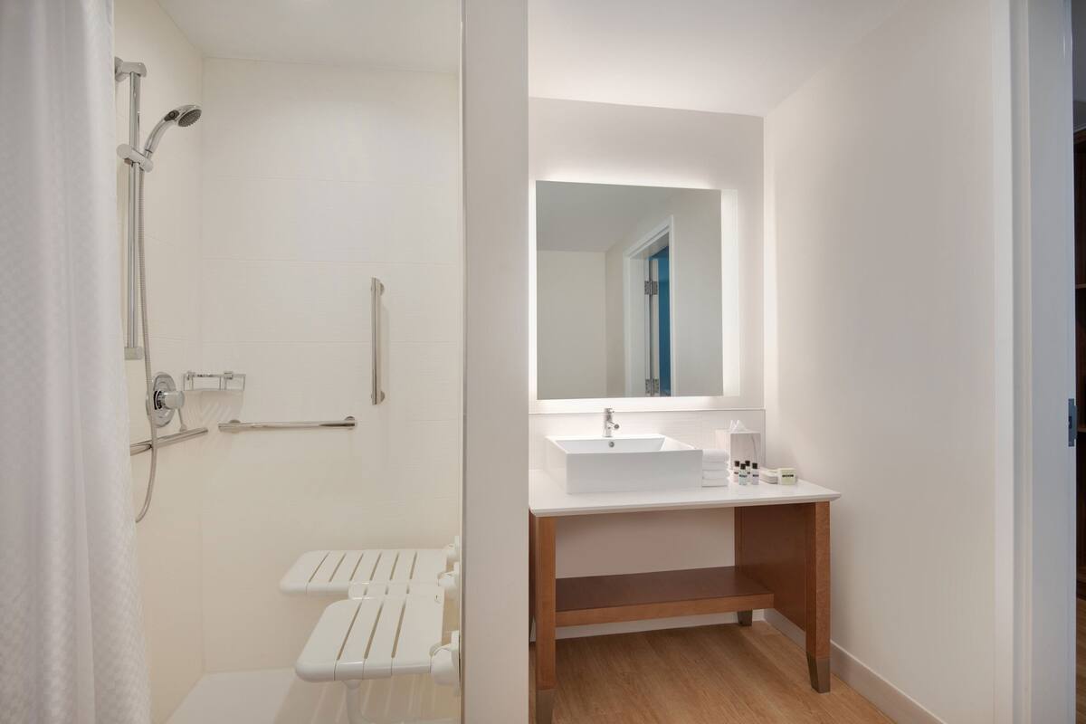 A modern bathroom with a shower, toilet, and vanity.