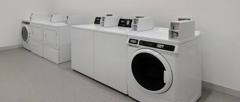 A laundry facility with multiple washing machines and dryers.