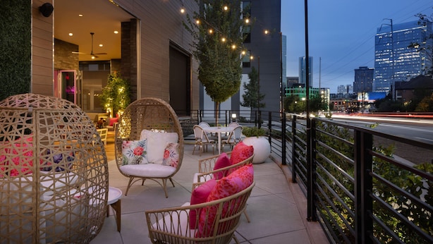 A balcony with wicker furniture, a Christmas tree, and city views. - Element by Marriott Atlanta Buckhead (Atlanta)