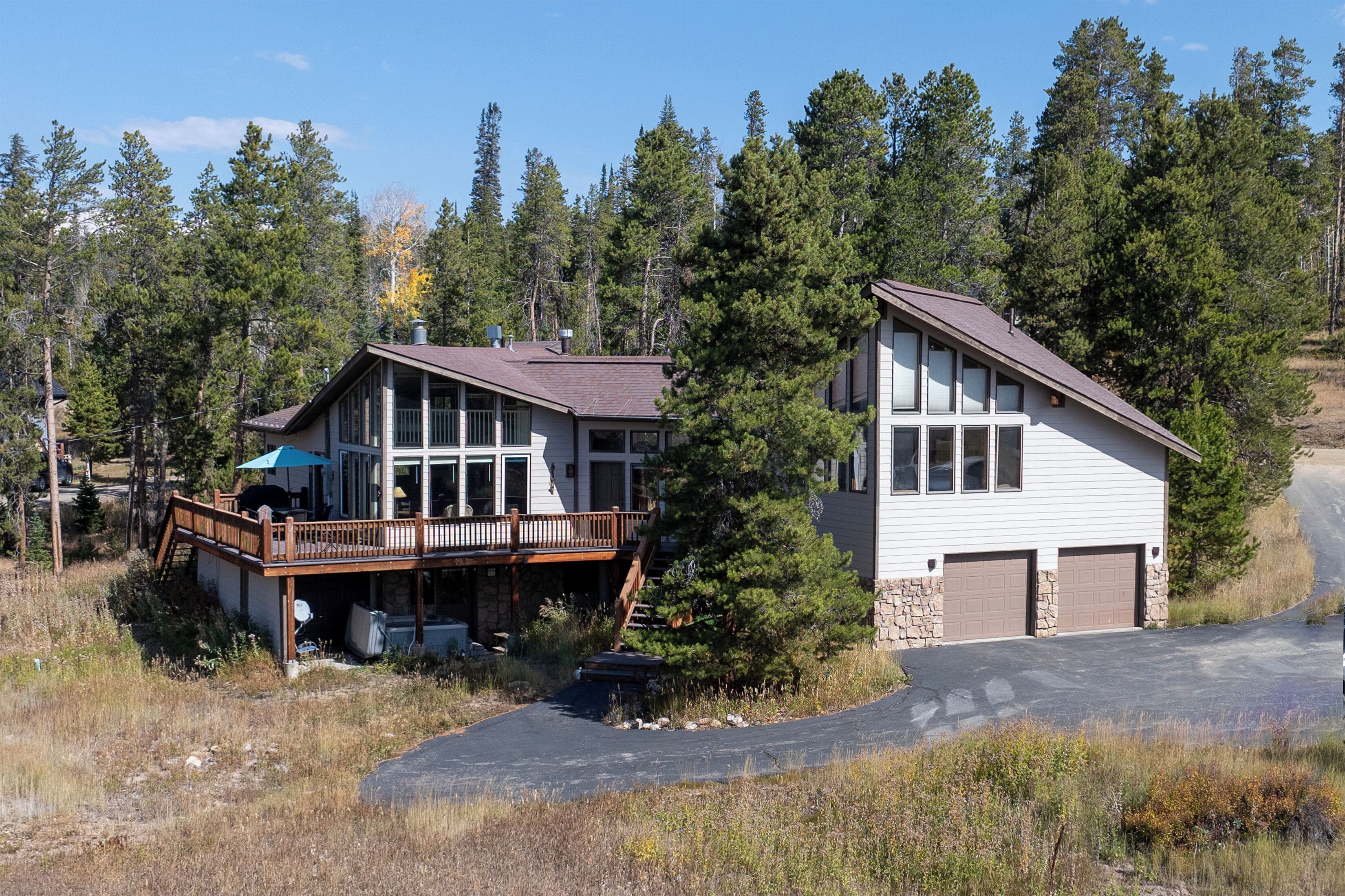 A two-story house with a deck, garage, and a driveway.