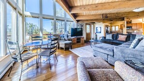 A spacious living area with a large window, a television, and a cozy seating arrangement. - Beautiful home in Fraser with great breathtaking views and private hot tub (Fraser)