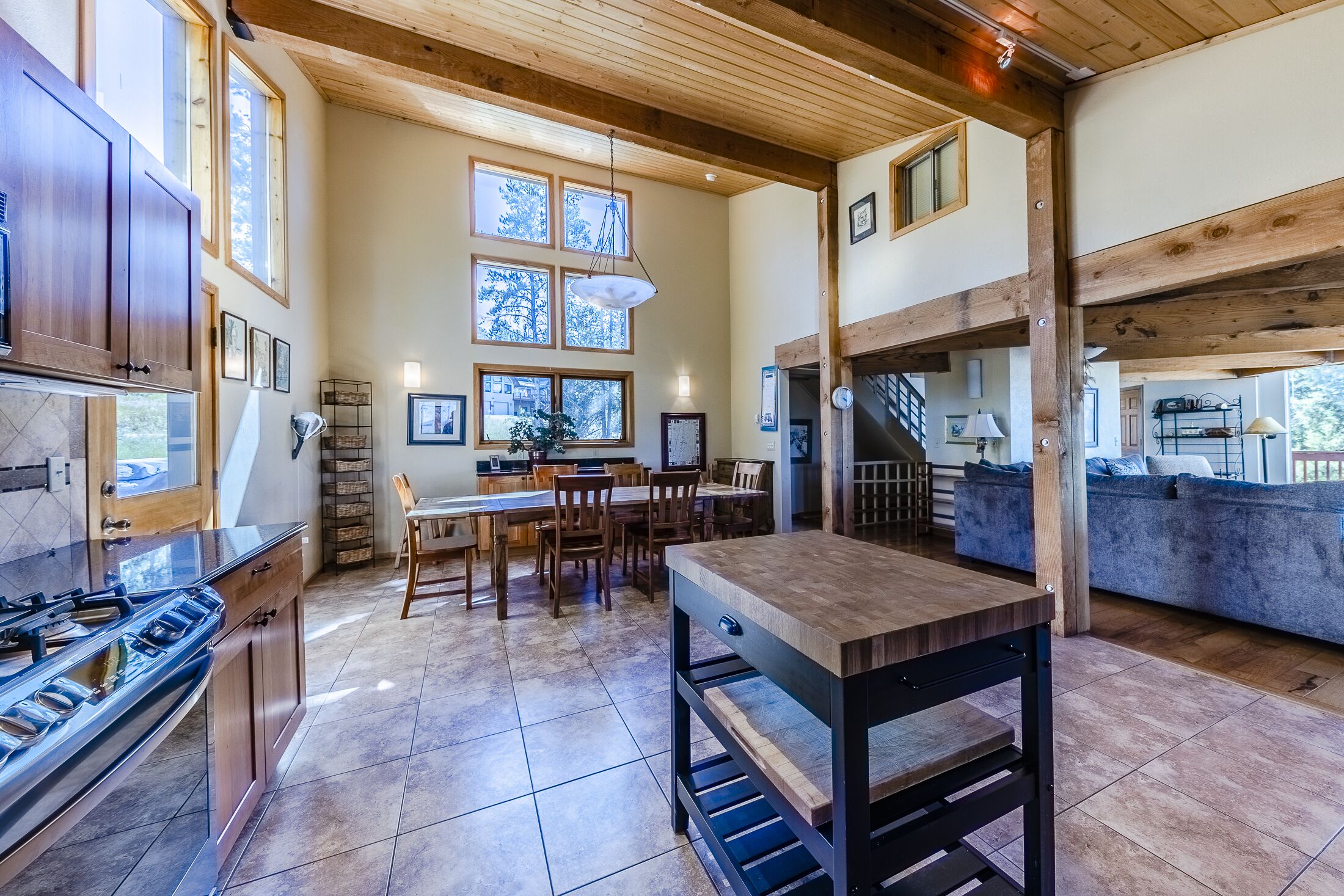 Une cuisine spacieuse avec des meubles en bois, un grand îlot central et un coin repas équipé de chaises.