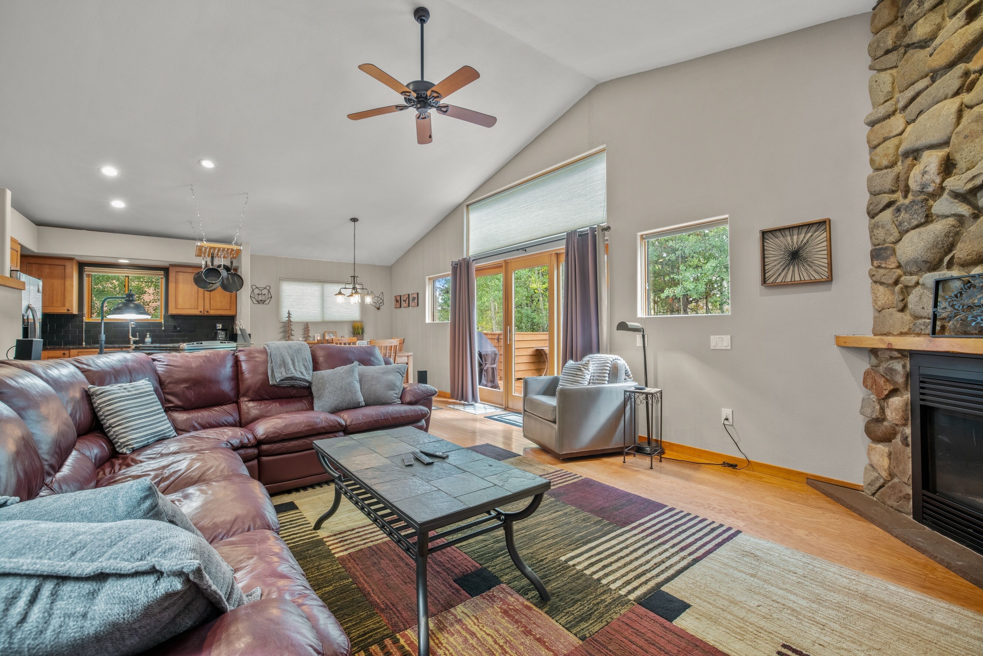 A spacious living room with a leather sectional sofa, a coffee table, and a fireplace.
