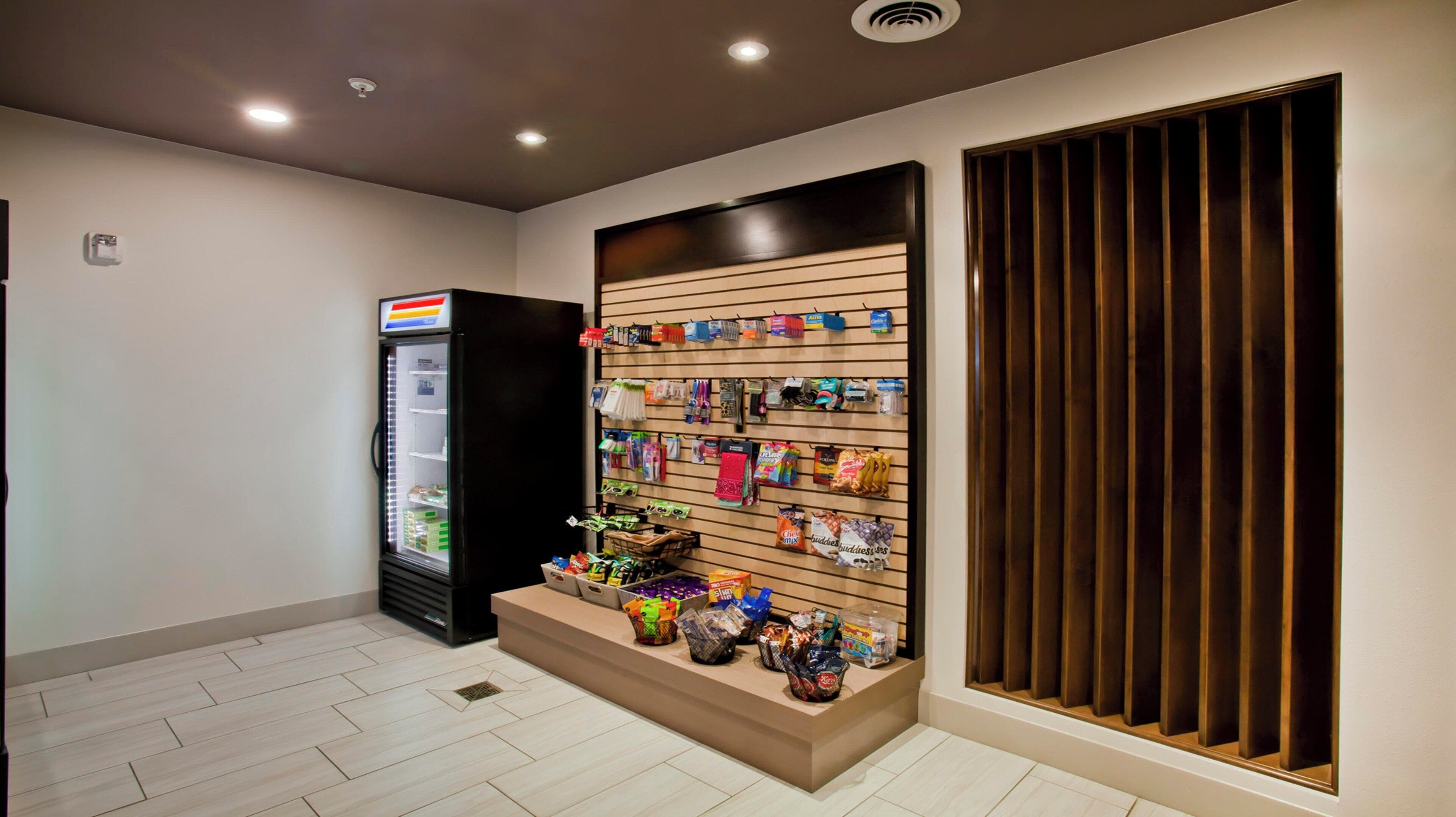 A clean, modern interior with a vending machine, a snack display, and a wooden panel wall.
