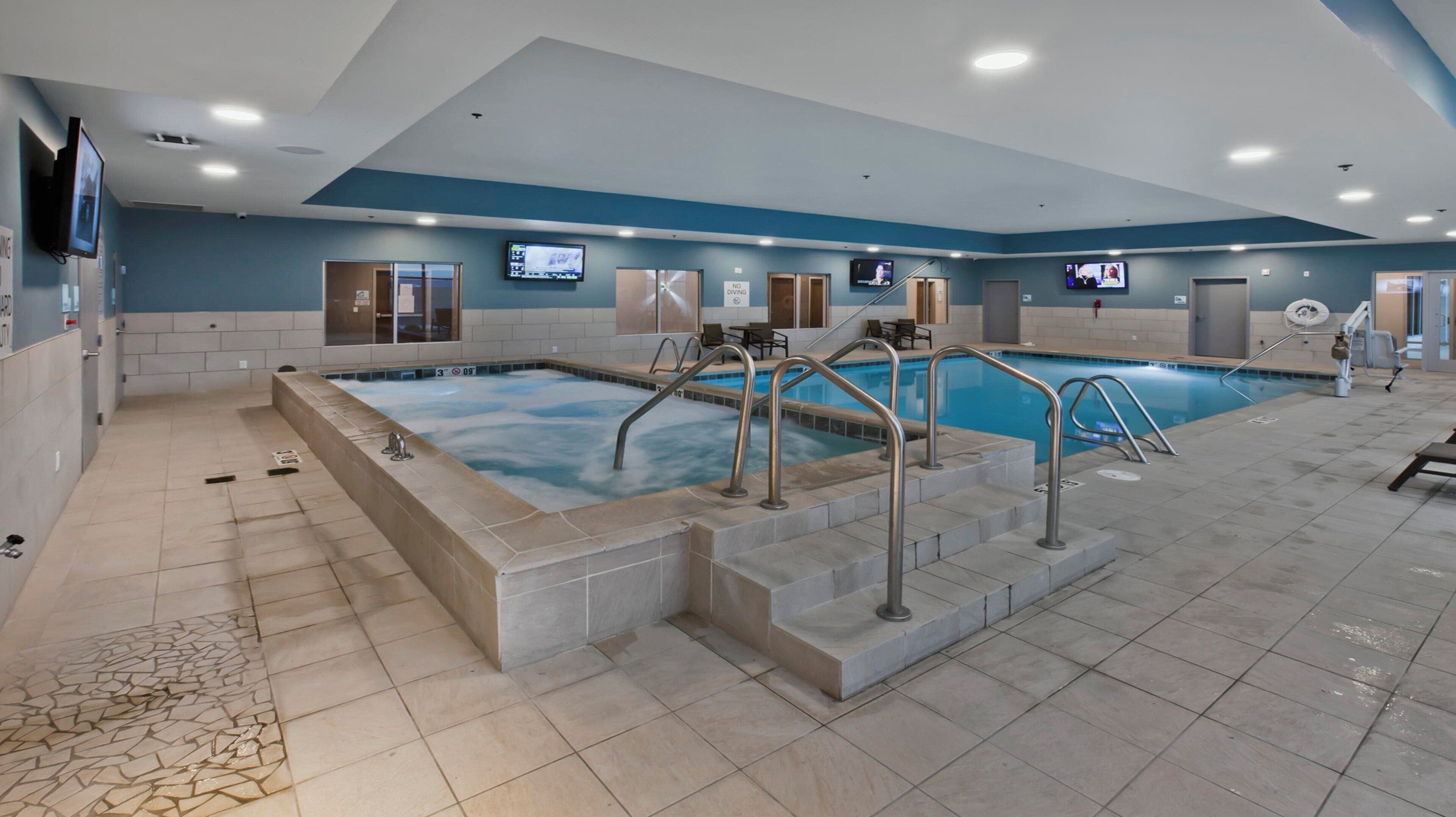 A large indoor swimming pool with multiple lanes, a changing room, and a seating area.