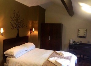 A hotel room with a bed, a wardrobe, a desk with a mirror, and wall-mounted lamps. - George & Dragon (Chester)