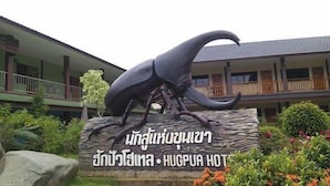 A large elephant sculpture in front of a hotel with a sign in a foreign language. - Hugpua Hotel (Pua)