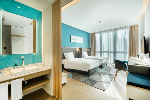 A modern hotel room with a large bed, a desk, a laptop, and a bathroom with a sink and mirror. - Holiday Inn Express Shanghai Zhangjiang by IHG (Shanghai)