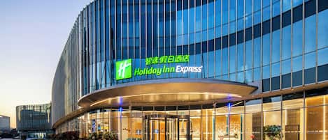 A Holiday Inn Express hotel with a modern glass facade and a curved entrance.