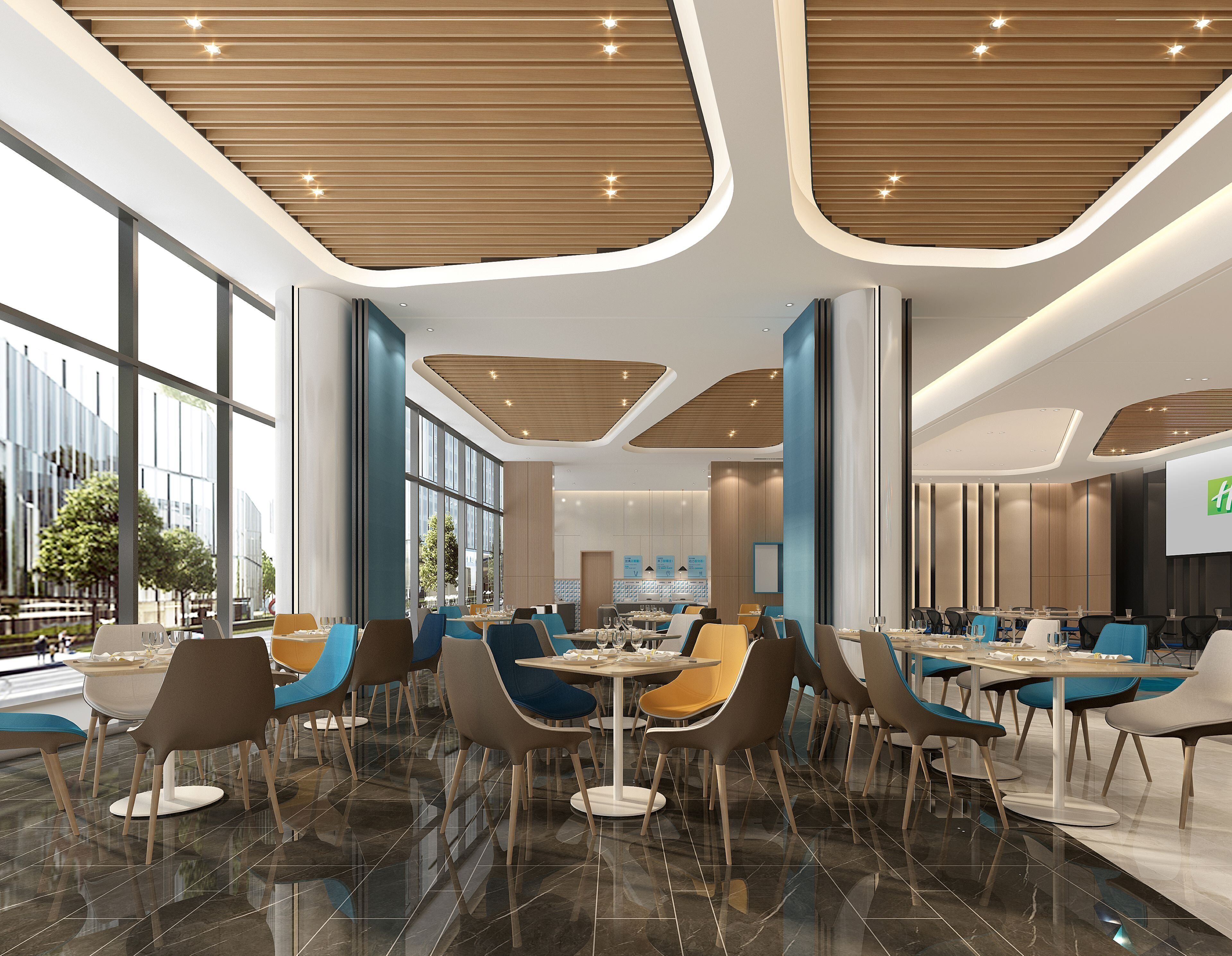 A modern dining area with tables and chairs, large windows, and a curved ceiling design.